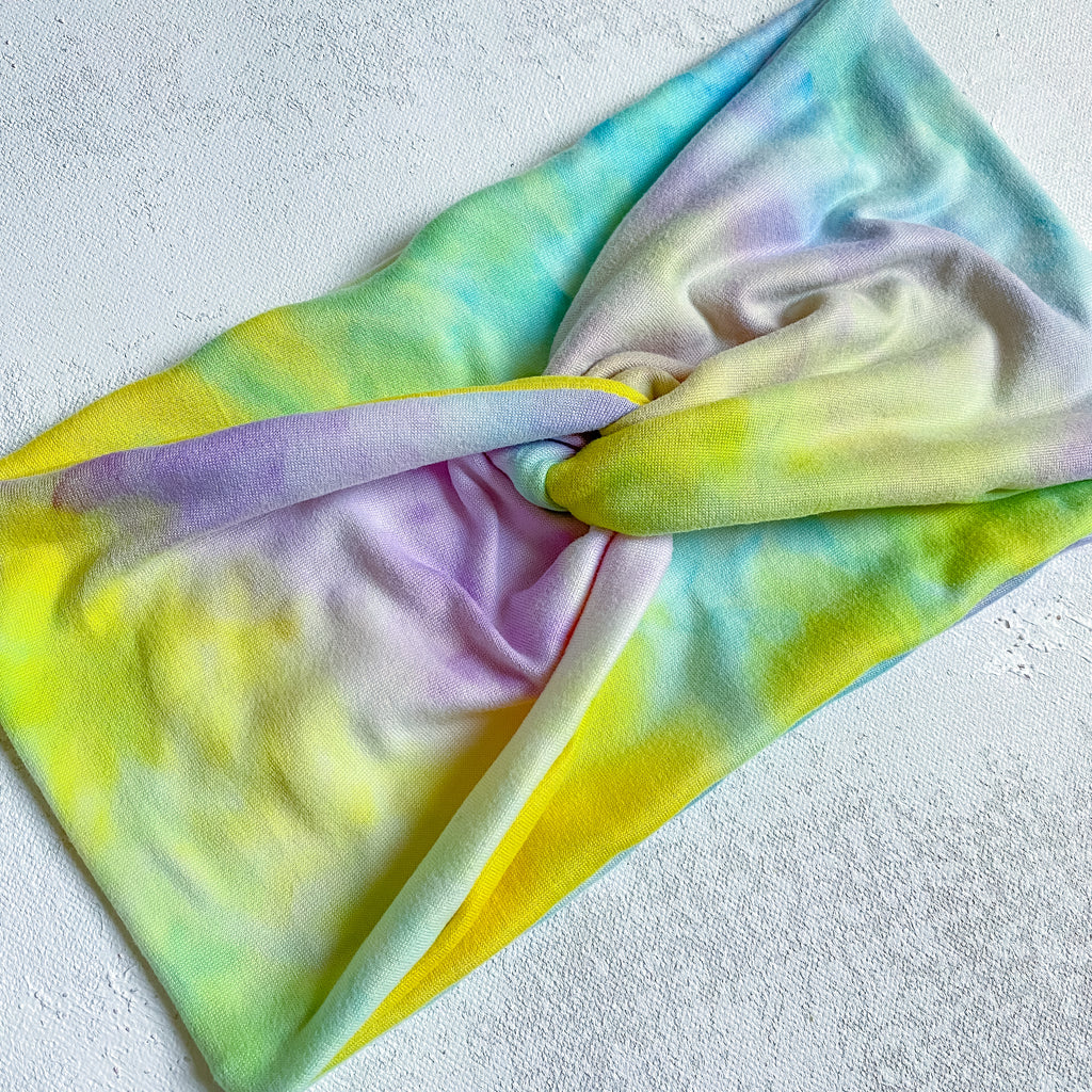 handmade wide fabric headband for women.  pastel tie dye in yellow, purple, and blue.