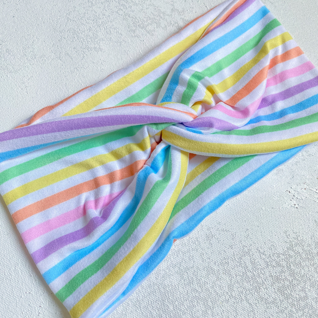 handmade wide fabric headband for women. white fabric with pastel rainbow stripes pattern 