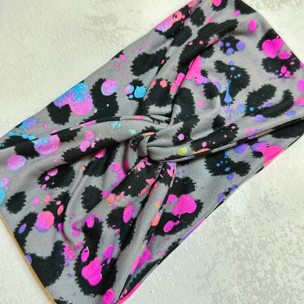 wide turban fabric headband for women.  grey with black leopard print and neon paint splatter.